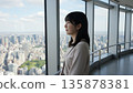 一名女子正在高樓的觀景台上欣賞風景。 135878381