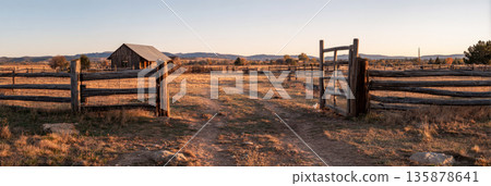 A classic farm gate made of wooden panels stands beside a lush green pasture. The cloudy sky adds a tranquil atmosphere to this rural landscape, making it peaceful and inviting, banner A classic farm gate made of wooden panels stands beside a lush green pasture. The cloudy sky adds a tranquil atmosphere to this rural landscape, making it peaceful and inviting, banner 135878641