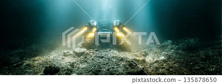 A massive robotic crawler moves along the ocean floor, collecting polymetallic nodules in deep water. Artificial lights pierce the murky darkness, revealing its path, banner A massive robotic crawler moves along the ocean floor, collecting polymetallic nodules in deep water. Artificial lights pierce the murky darkness, revealing its path, banner 135878650