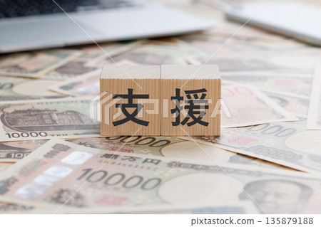 A block with the word "support" written on top of money A block with the word "support" written on top of money 135879188