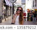 Woman walking on shopping street decorated for holidays in Beverly Hills  135879212