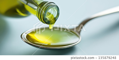 Olive oil pouring spoon close up, fresh golden liquid flow healthy cooking concept 135879248