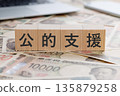一塊寫著「公眾支持」字樣的方塊，上面還放著錢。 135879258