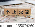 一塊寫著「非法福利」字樣的牌子，放在鈔票上。 135879260