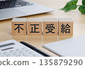 桌上放著一個寫著「非法所得」字樣的方塊。 135879290