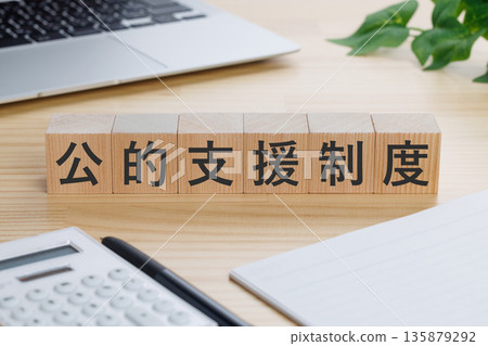桌上放著一個寫著「公共援助系統」字樣的方塊。 135879292