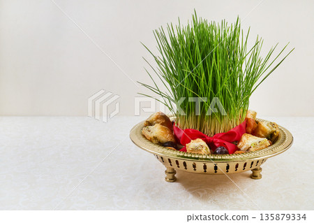 Nowruz sabzeh grass and baklava on haft-sin display 135879334