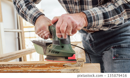 Carpenter at work, restoring an old wooden window. Carpentry. 135879416