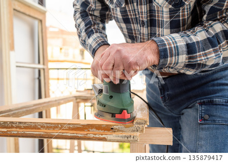 Carpenter at work, restoring an old wooden window. Carpentry. Carpenter at work, restoring an old wooden window. Carpentry. 135879417
