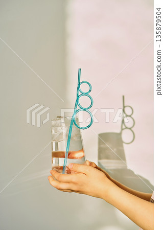 Hands holding refreshing glass of water with ice 135879504