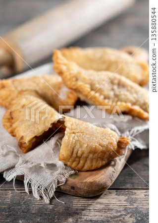 Homemade sweet pumpkin empanadillas on wooden table Homemade sweet pumpkin empanadillas on wooden table 135880544