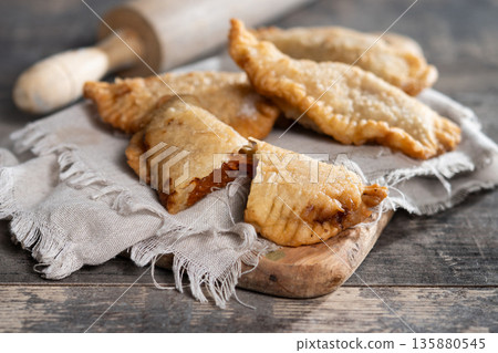 Homemade sweet pumpkin empanadillas on wooden table 135880545