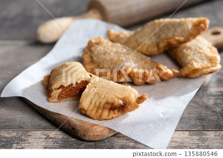 Homemade sweet pumpkin empanadillas on wooden table 135880546