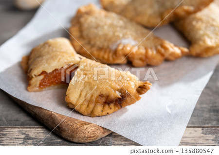 Homemade sweet pumpkin empanadillas on wooden table Homemade sweet pumpkin empanadillas on wooden table 135880547