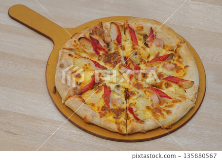 top view pizza with crab sticks, mushrooms, and pineapple placed in a wooden tray with handle on the table background, food, eat, hot, copy space 135880567