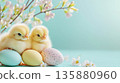 Three yellow chicks in close-up among pastel Easter eggs and willow branches on a mint background, a spring composition for Easter, holidays, and greeting cards.	 135880960