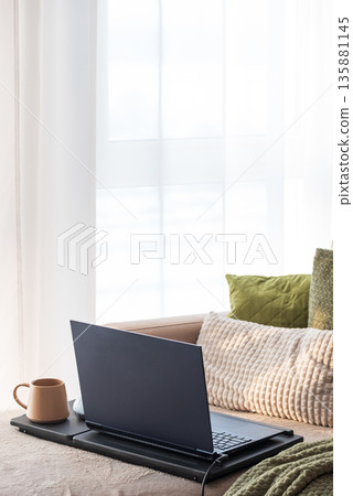 Laptop and Coffee Mug on Lap Desk. Cozy Morning Home Workspace with Green Accents Laptop and Coffee Mug on Lap Desk. Cozy Morning Home Workspace with Green Accents 135881145