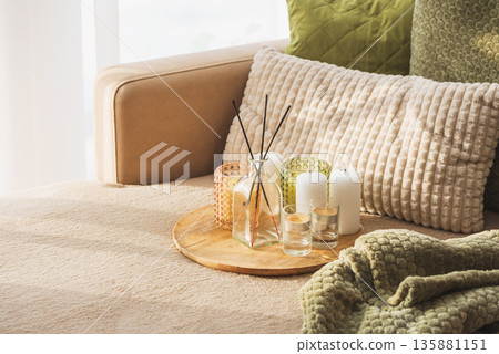 Candles and Reed Diffuser on Wooden Tray. Cozy Home Decor lifestyle with Cushions 135881151