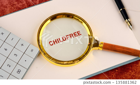A golden magnifying glass clearly magnifies the word childfree in red letters on a light paper A golden magnifying glass clearly magnifies the word childfree in red letters on a light paper 135881362