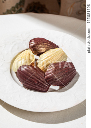 Assorted chocolate madeleine cakes on white plate 135881598