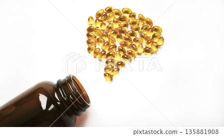 Omega 3 fish oil tablets spilling from a glass jar shaped like a human brain on a white background. Brain health concept. Omega 3 fish oil tablets spilling from a glass jar shaped like a human brain on a white background. Brain health concept. 135881908