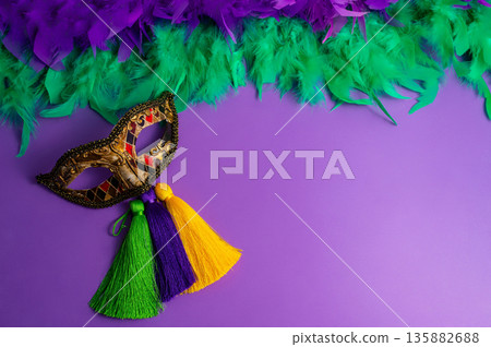 Vibrant Mardi Gras background with mask, beads, and festive decorations Vibrant Mardi Gras background with mask, beads, and festive decorations 135882688