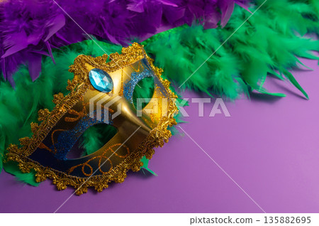 Vibrant Mardi Gras background with mask, beads, and festive decorations Vibrant Mardi Gras background with mask, beads, and festive decorations 135882695