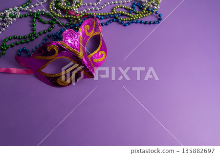 Vibrant Mardi Gras background with mask, beads, and festive decorations 135882697