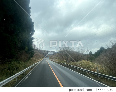 Straight road running through the mountains and cloudy sky. Local road. Straight road running through the mountains and cloudy sky. Local road. 135882930
