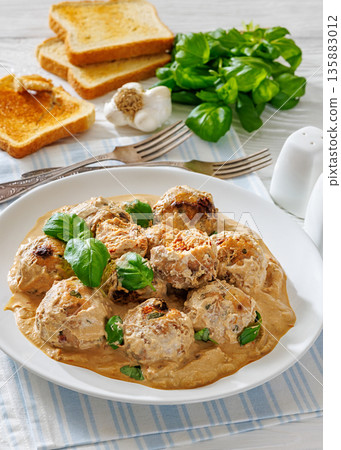 Chicken meatballs in creamy sun dried tomato sauce 135883012