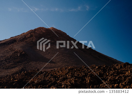 Mount Teide Volcano Under Blue Sky in Tenerife, Canary Islands. Volcanic peak Mount Teide Volcano Under Blue Sky in Tenerife, Canary Islands. Volcanic peak 135883412
