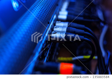 Rear console of control panel for equipment with connection cables to connect the equalizer, amplifier, microphones, speakers and other musical instruments. Connections of professional sound system. Rear console of control panel for equipment with connection cables to connect the equalizer, amplifier, microphones, speakers and other musical instruments. Connections of professional sound system. 135883584