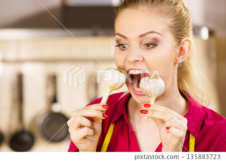 Crazy girl eating garlic vegetable Crazy girl eating garlic vegetable 135883723