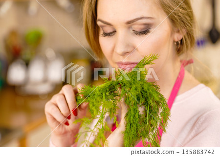 Woman smelling green dill herb Woman smelling green dill herb 135883742