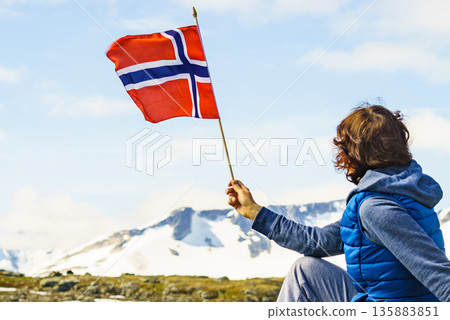Tourist with norwegian flag in mountains Tourist with norwegian flag in mountains 135883851