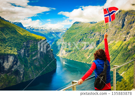 Tourist over Geirangerfjord with norwegian flag 135883878
