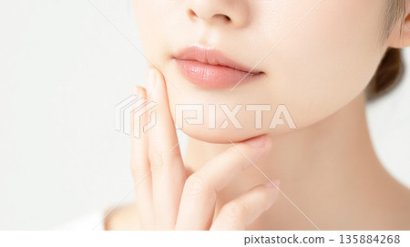 一位年輕女子用手撫摸著臉頰的特寫鏡頭 一位年輕女子用手撫摸著臉頰的特寫鏡頭 135884268