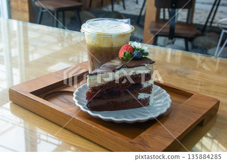 Coffee and chocolate cake with ice coffee in coffee shop. Coffee and chocolate cake with ice coffee in coffee shop. 135884285