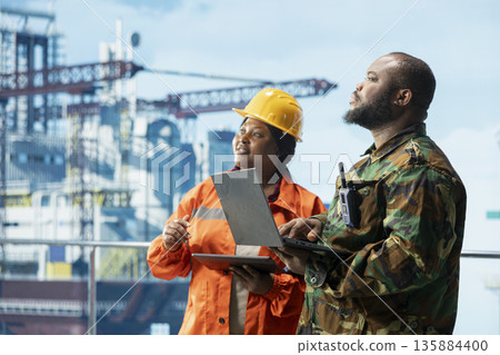 Naval unit conducting maritime interdiction operations around drilling sites, working with offshore platform technician. Army soldier on drilling barge performs security patrols to prevent piracy Naval unit conducting maritime interdiction operations around drilling sites, working with offshore platform technician. Army soldier on drilling barge performs security patrols to prevent piracy 135884400