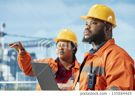 Close up of offshore platform engineering team configuring derrick management systems for more efficient oil extraction. Drilling rig coworkers doing seabed analysis using laptop software Close up of offshore platform engineering team configuring derrick management systems for more efficient oil extraction. Drilling rig coworkers doing seabed analysis using laptop software 135884485