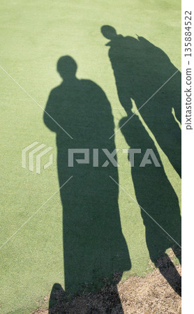Shadows of a family reflected on the lawn Shadows of a family reflected on the lawn 135884522