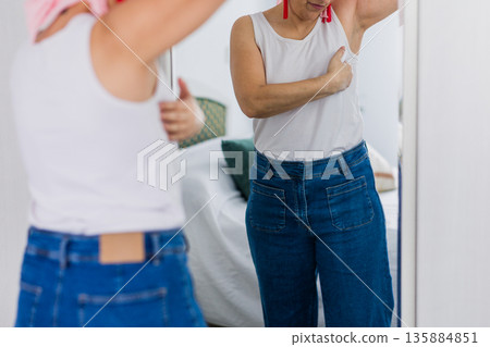 Woman performing breast self examination for cancer awareness Woman performing breast self examination for cancer awareness 135884851