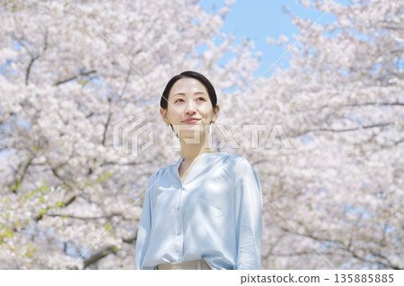 A woman taking a walk with the cherry blossoms in full bloom A woman taking a walk with the cherry blossoms in full bloom 135885885