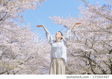 A woman taking a deep breath in front of cherry blossoms A woman taking a deep breath in front of cherry blossoms 135885887