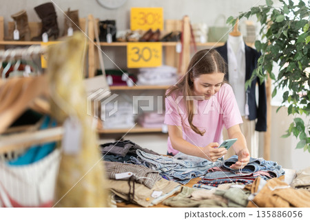 Girl scans pants and jeans Girl scans pants and jeans 135886056