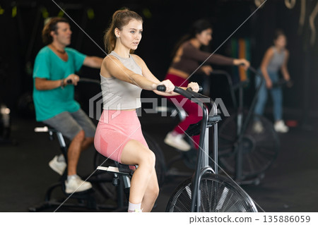 Young woman doing exercises on air bike 135886059