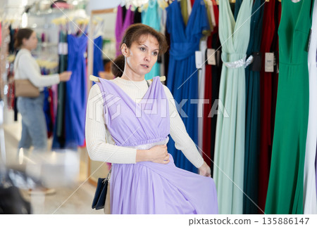 Adult woman choosing dress in store 135886147