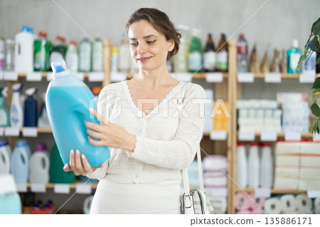 Young woman buyer chooses detergent in store 135886171