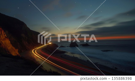 With the ocean on one side and the imposing coastal cliffs on the other car light trails guide the way through this scenic and dangerous route 135886398