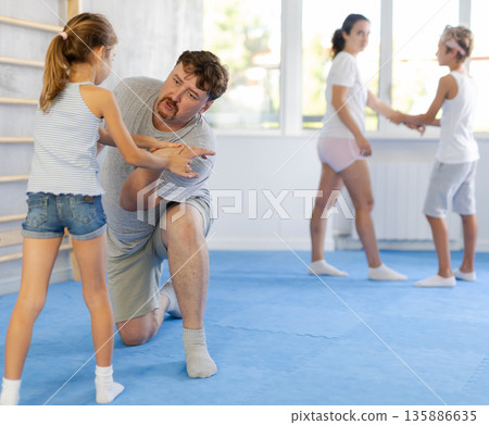 Father and daughter training self-defense techniques Father and daughter training self-defense techniques 135886635